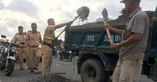 CSGT giúp lao công thu gom đá dăm